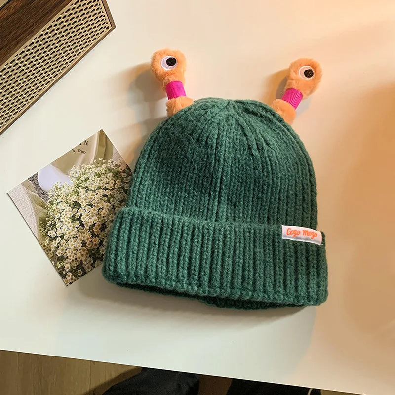 Green knit beanie with a small tag on a light surface