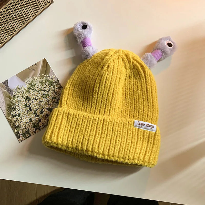 Yellow knit beanie with a brand label on a light surface
