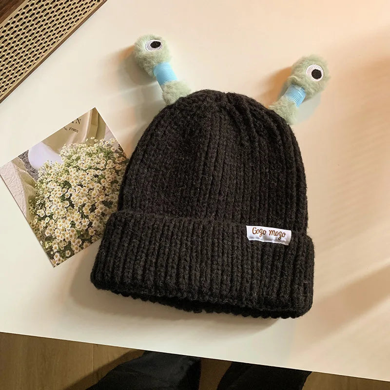 Black knit beanie with a small logo on a light surface